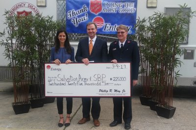 Phillip May, president and CEO of Entergy Louisiana, presents donations aimed at helping the ongoing recovery from last year’s historic floods to Elizabeth Egle of SBP and Capt. Brett Meredith of The Salvation Army of Greater Baton Rouge.